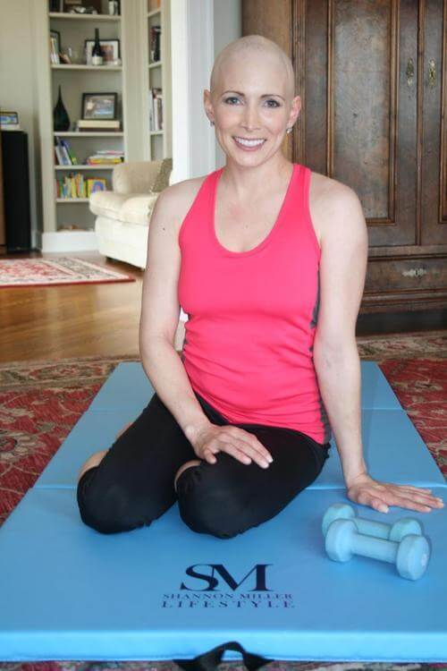 bald woman smiling on workout mat